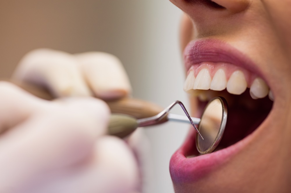dentista-examinando-paciente-blanqueamiento-dental